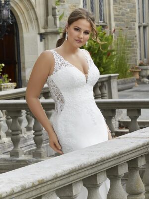 El vestido de novia presenta aplicaciones de encaje veneciano escarchado sobre satén elástico con cola festoneada recortada